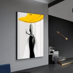 a black and white painting hanging on the wall next to a blue chair in a room