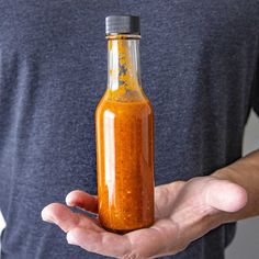 a man holding a bottle of hot sauce in his hands