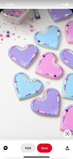 several decorated heart shaped cookies sitting on top of a table