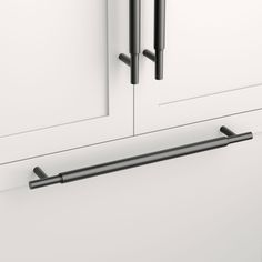 a black handle on a white cabinet with two doors and one door is open to show the handles