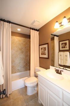 a bathroom with a sink, toilet and bathtub next to a shower curtain in it