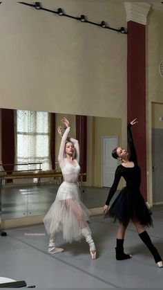 two ballerinas are in the middle of a dance class with their arms stretched out