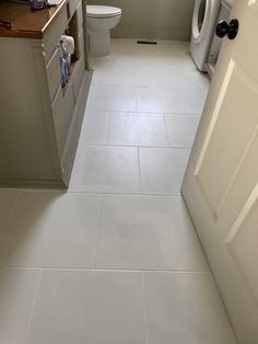 a bathroom with a toilet, sink and washer dryer on the counter top