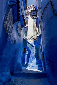 an alley way with blue walls and steps