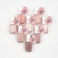 pink nail polish arranged in a heart shape with the word love written on it and hearts painted on them