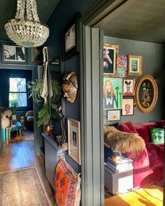 a living room filled with lots of furniture and pictures on the wall next to a doorway