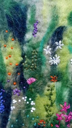 a close up view of some flowers on a piece of fabric with green grass and blue sky in the background