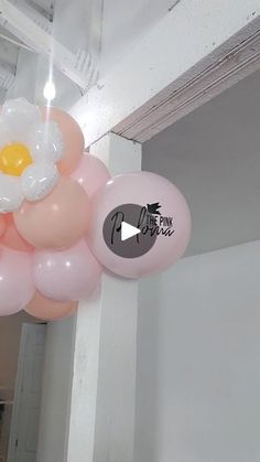 some balloons are hanging from the ceiling with an egg on top of one balloon that is floating in the air