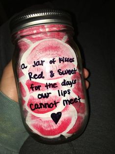 a person holding a mason jar with writing on it and hearts painted on the lid