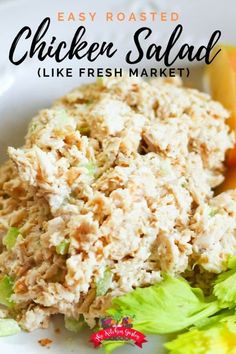 chicken salad on a white plate with lettuce and carrots in the background