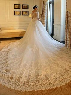 a woman in a wedding dress looking out the window