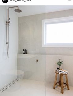 a bathroom with a stand up shower and white walls