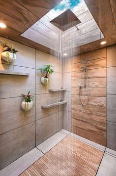 a shower with wooden walls and flooring next to a skylight in a bathroom