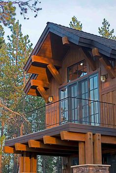 a large wooden house sitting in the middle of a forest