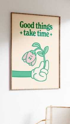 a poster hanging on the wall above a chair and table with a plant in it