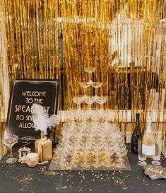 a table topped with lots of gold confetti next to a black and white sign