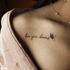 the back of a woman's shoulder with a tattoo saying, love your dreams