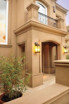 a house with a potted plant in front of it and two lights on the outside