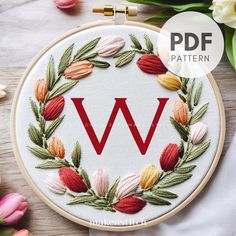 the letter w is surrounded by flowers and leaves on a white background with text overlay