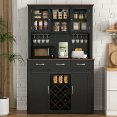 a black cabinet with wine glasses on it in a kitchen next to a potted plant