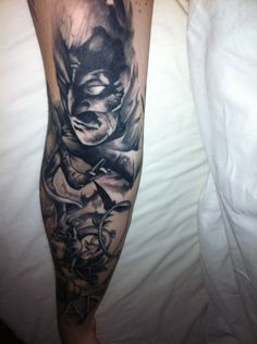 a man with a batman tattoo on his leg