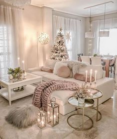 a living room filled with white furniture and christmas decorations