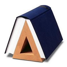 an open book sitting on top of a wooden stand with a triangle shaped cover over it