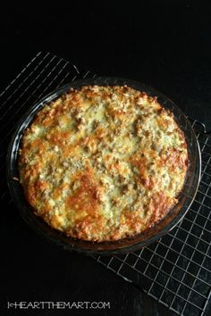 a baked pizza sitting on top of a metal rack next to a black countertop