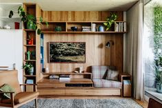 a living room filled with lots of furniture and plants on top of it's shelves