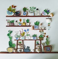 several shelves are decorated with ceramic cactus and succulents