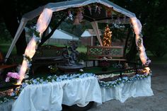 an outdoor gazebo decorated with flowers and lights