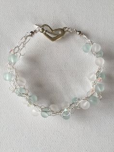 a silver bracelet with glass beads and a heart charm