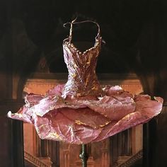 a dress made out of pink paper sitting on top of a table