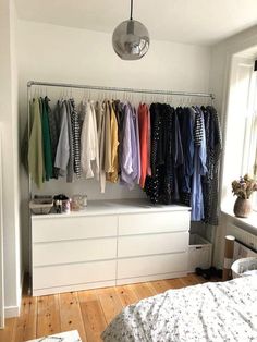 a bedroom with clothes hanging on the wall