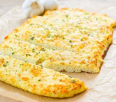 an omelet is cut in half on a piece of wax paper with garlic