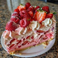 a piece of cake with strawberries and cream on top sitting on a countertop