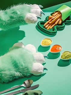 a table topped with lots of food and utensils on top of green surface