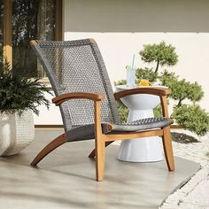 a chair sitting on top of a patio next to a potted plant