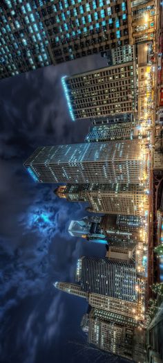 an aerial view of skyscrapers in the city at night with bright lights on them