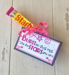 a candy bar wrapped in pink ribbon next to a sign that says, burst on that star