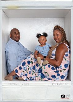 a man, woman and child are sitting in a white box with blue flowers on it