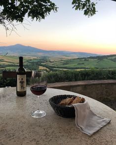 a glass of wine sitting on top of a table next to a bottle of wine