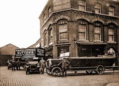 an old black and white photo of men standing in front of a building with signs on it