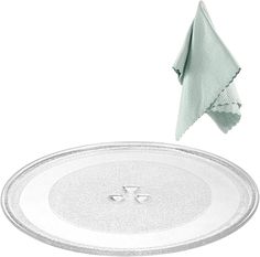 a white plate with a green towel hanging from it's side next to a dish cloth