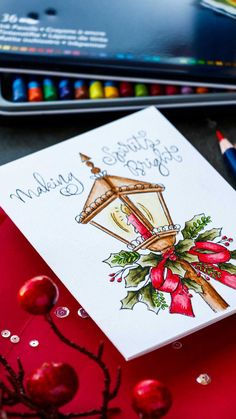 a christmas card sitting on top of a table next to colored crayons and pencils