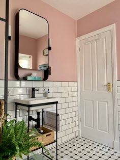 a bathroom with pink walls and black and white tile