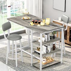 a kitchen table with two stools in front of it and a book shelf on the other side