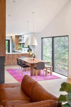 a living room filled with furniture and a fire place next to a dining room table