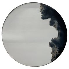 a circular mirror with black and white paint on it