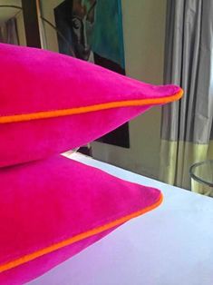 two pink pillows sitting on top of a bed